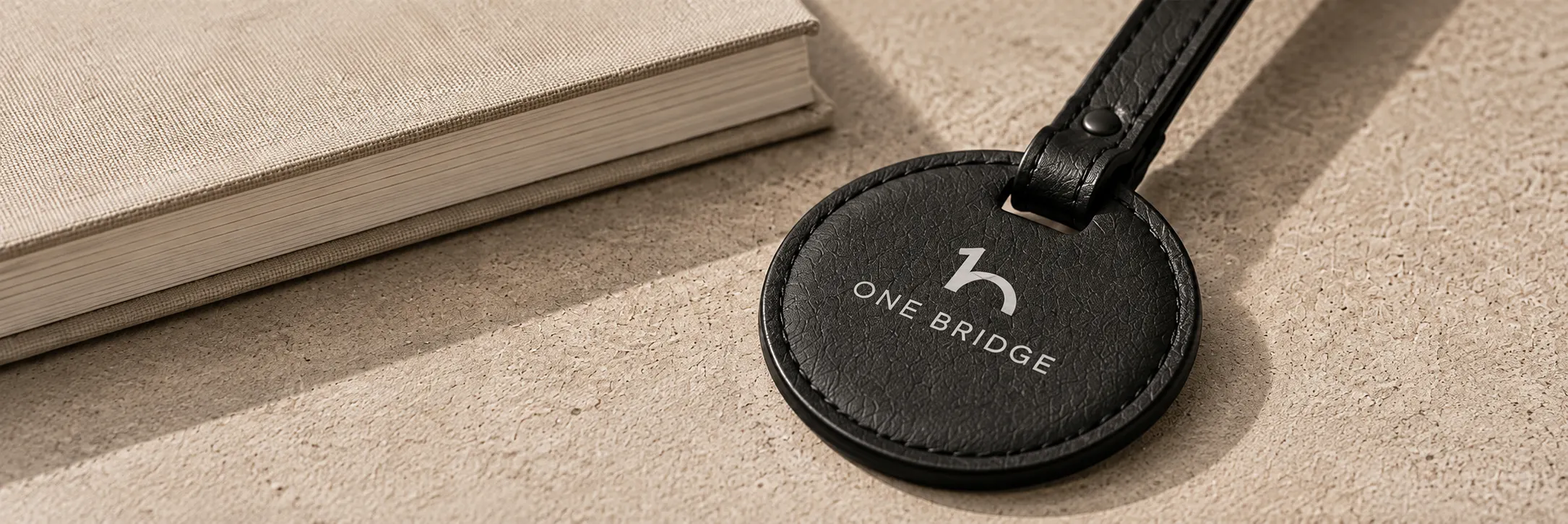 OneBridge leather keychain resting on a notebook